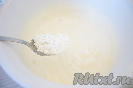 Затем, взбивая на маленькой скорости миксера или вручную лопаточкой, постепенно столовой ложкой добавить просеянную муку с крахмалом. Перемешать до равномерного распределения мучной смеси.&nbsp;

