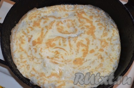 Жарить яичный блинчик на среднем огне до подрумянивания с двух сторон, затем переложить на тарелку. Аналогично взбить вилкой ещё 1 сырое яйцо с небольшим количеством соли и тоже пожарить блинчик на сковороде, смазанной маслом.