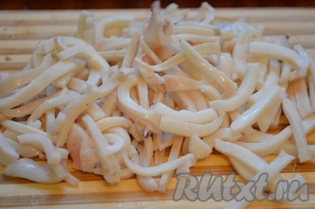 Для того чтобы сварить кальмара, его нужно опустить в кипящую воду и варить 2 минуты после закипания воды. Затем остудить, очистить от плёнок и хорды. Отварного кальмара нарезать мелкой соломкой.