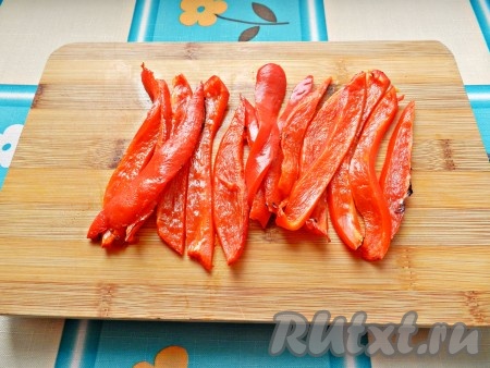 Запечённый перец очистить от кожицы и нарезать полосками.