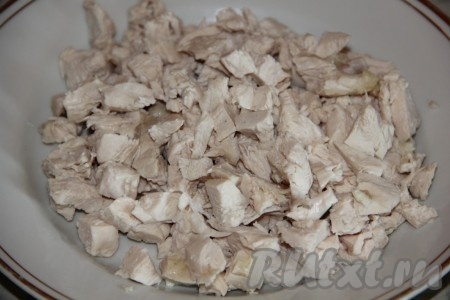 Пока тесто поднимается, можно заняться начинкой для пиццы. Прежде всего нужно отварить в подсоленной воде кусочки курицы (варить с момента закипания минут 30), затем достать из бульона, остудить, отделить от костей, если они есть. Нарезать куриное мясо на небольшие кубики.