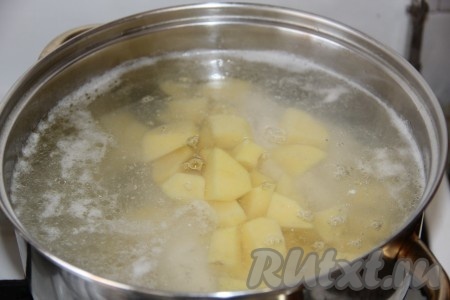 Вымытые части курицы поместить в кастрюлю, в которой будете варить суп, влить 2 литра воды, поставить на огонь. После закипания убрать с поверхности пену и варить мясо минут 25-30. Затем убрать кастрюлю с огня, кусочки курицы достать из бульона, дать немного остыть, отделить от костей. Процедить бульон, вернуть его в кастрюлю, поставить на огонь. После закипания бульона выложить в кастрюлю очищенный картофель, нарезанный на средние кусочки, и мясо курицы без костей.