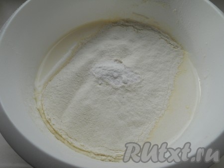 Добавить соду, перемешать и постепенно всыпать просеянную муку.