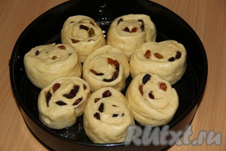 Выкладываем булочки в форму для выпечки, смазанную растительным маслом, оставляя место между ними. Накрываем форму с булочками полотенцем и оставляем в тепле на 30-40 минут.