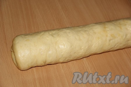 Сворачиваем тесто в плотный рулет, начиная с широкой стороны.