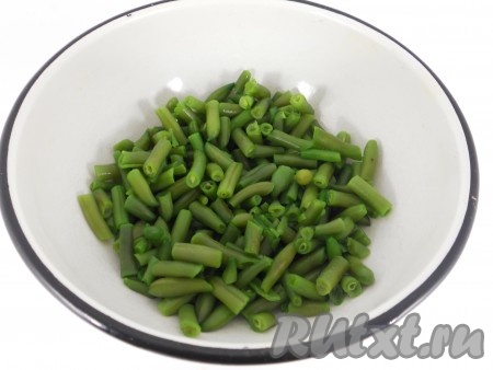 Зеленую фасоль залить водой и поставить на огонь. Варить 6-8 минут после закипания, после чего откинуть на дуршлаг и промыть холодной водой. Дать воде стечь и поместить фасоль в глубокую миску.

