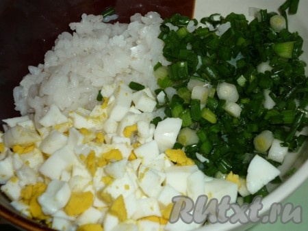 Пока поднимается тесто, подготовим начинку для пирожков. Для этого рис нужно промыть водой, после этого выложить в кастрюлю с кипящей подсоленной водой и отварить до готовности (в течение минут 20-25 с момента закипания), затем воду слить, рис остудить. 4 яйца отвариваем в течение 10 минут с момента закипания воды, после этого остужаем и очищаем. Зелёный лук моем, обсушиваем. В миску выкладываем варёный рис, добавляем мелко нарезанные зелёный лук и варёные яйца, солим и перчим по вкусу, перемешиваем и начинка для наших пирожков готова.