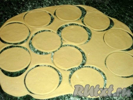 Тесто тонко раскатываем на присыпанной мукой поверхности и вырезаем стаканом кружочки.
