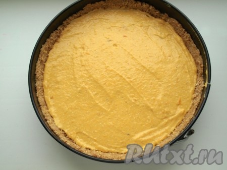 Достаём форму с основой для чизкейка из холодильника и на основу из печенья равномерно выкладываем тыквенно-творожную массу.