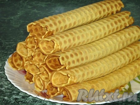 В разогретую и смазанную маслом вафельницу наливаем 1-1,5 столовые ложки теста и выпекаем до золотистого цвета. Приготовленную горячую вафлю сворачиваем трубочкой.
