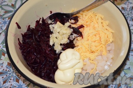 Смешать в миске кальмаров, сыр, свеклу, посолить салат по вкусу, добавить натёртый на мелкой тёрке (или пропущенный через пресс) чеснок и майонез (или сметану), перемешать.