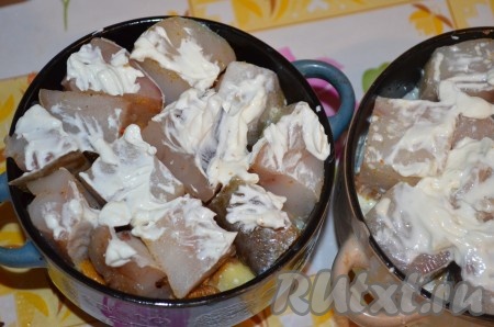 Остальную сметану смешать с водой, при необходимости посолить и поперчить. Залить горшочки с рыбой и картошкой так, чтобы воды было чуть меньше половины.
