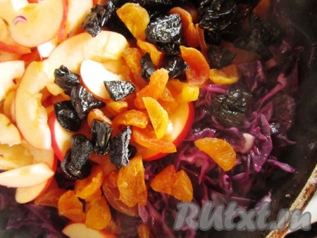 Добавьте в сковороду к капусте яблоки и сухофрукты.