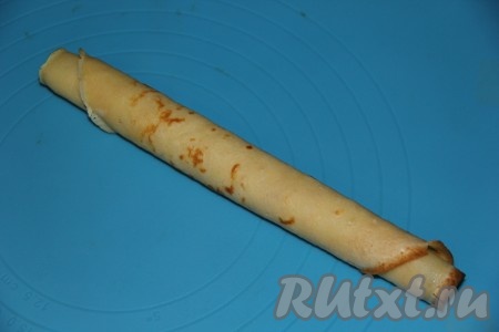 Свернуть блинчик с начинкой в плотную трубочку.