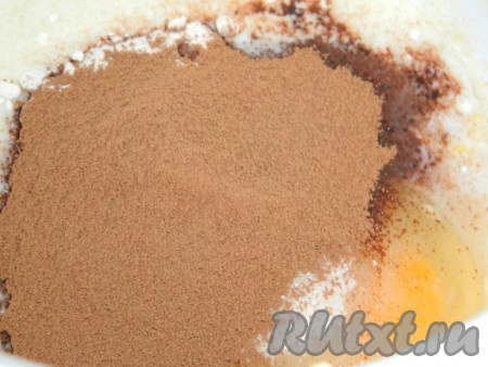 Теперь замесим тесто для бисквита, для этого в глубокой миске соединяем яйцо, сахар, растительное масло, молоко и горячую воду. Всыпаем муку, разрыхлитель и какао-порошок, аккуратно перемешиваем, масса должна получиться однородной, по консистенции напоминать густую сметану.