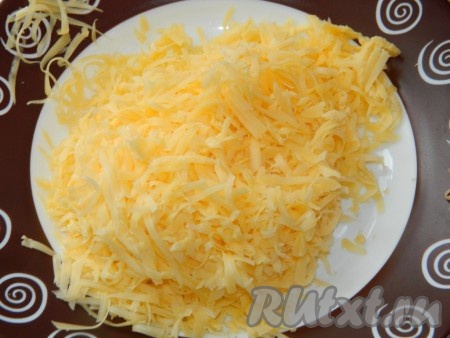 Сыр натираем на крупной тёрке и высыпаем в тесто, перемешиваем венчиком. Добавляем муку, молоко, растительное маслом и соль, перемешиваем, затем, не прекращая перемешивать, тонкой струйкой вливаем кипящую воду, перемешиваем до однородности. 