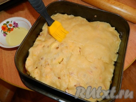 Вторую часть теста раскатываем и выкладываем сверху. Так как тесто рыхлое, я его разделила на 4 кусочка и так по одному их раскатала и накрыла пирог. Сверху смазываем белком.
