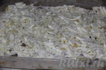 Предварительно замороженное сливочное масло натереть на крупной тёрке, выкладывая равномерно следующим слоем. Очищенные яйца разделить на желтки и белки. Белки натереть на крупной тёрке и выложить следующим слоем салата, при желании можно немного подсолить. Слегка смазать этот слой майонезом.