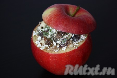 Положить начинку поверх творога, накрыть шляпкой от яблока. Сделать в яблоке 5-7 проколов зубочисткой, поставить на тарелку и отправить в микроволновку на 3-5 минут при полной мощности (возможно и дольше, зависит от сорта, размера и количества яблок).
