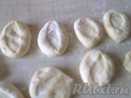 Формируем лепёшки. Каждый кусочек обмакиваем срезом в муку, немного прижимаем рукой и слегка раскатываем в кружок.
