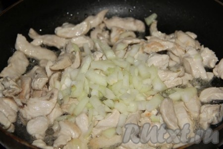 К обжаренному куриному филе выкладываем очищенный и мелко нарезанный лук, перемешиваем. Обжариваем минуты 3 (до прозрачности лука), иногда перемешивая.
