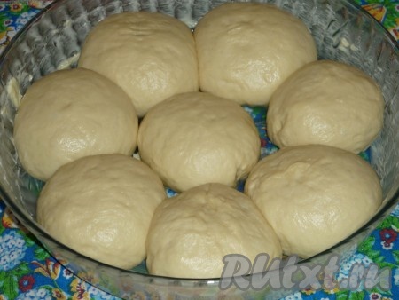 Тесто скатать в валик, нарезать на одинаковые кусочки (я разрезала на 8 частей). Каждый кусочек скатать в шарик. Затем каждый шарик раскатать в лепёшку, в центр которой выложить часть начинки из яблок (я зрительно разделила начинку на 8 частей, поскольку формировала 8 булочек). Защипнув края лепёшки над начинкой, сформировать булочку. Аналогично сформировать все 8 булочек. Форму для выпечки смазать сливочным маслом и выложить булочки швом вниз. Дать им подойти в течение 7-10 минут.