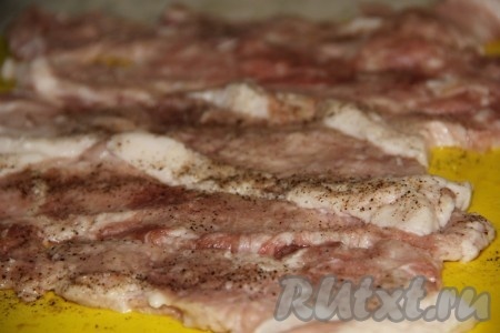 Свинину моем, обсушиваем. Разрезаем свинину на порционные кусочки толщиной примерно 1 сантиметр. Отбиваем каждый кусочек кулинарным молоточком до толщины ориентировочно 5 миллиметров. Солим и перчим.