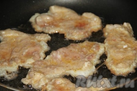 На сковороде хорошо разогреваем растительное масло, затем выкладываем отбивные из свинины в кляре. Обжариваем мясо с двух сторон на среднем огне до образования золотистой корочки (жарим примерно по 4-5 минут с каждой стороны).