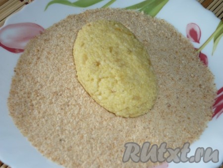 Обваливаем биточки из пшенной каши в панировочных сухарях.
