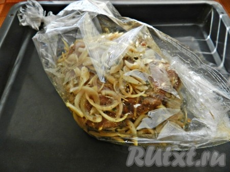 Затем свиную шею с луком и маринадом поместить в рукав для запекания. Завязать рукав с двух сторон, переложить на противень (или в форму для запекания) и поставить в разогретую до 190 градусов духовку на 1,5 часа. Открывать рукав в конце запекания, чтобы мясо зарумянилось, не нужно. Свинина, благодаря соевому соусу, и так получится достаточно румяной.