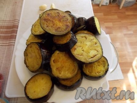 Баклажаны вымыть и нарезать толстыми кружочками. В сковороде разогреть растительное масло, добавить куркуму, перемешать и обжарить баклажаны до оранжевой корочки. 
