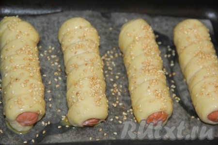 Смазать верх теста взбитым желтком и посыпать кунжутом. Поставить противень в разогретую духовку и выпекать при 200 градусах до золотистого цвета.
