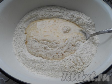 Муку просеять в глубокую миску. Добавить опару и кефирную смесь.