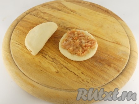 На каждый кружочек поместить по 1 столовой ложке фарша, разровнять его по всей лепешке. Свернуть пополам.
