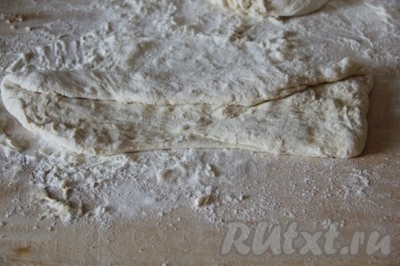 Поднявшееся тесто делим на 3 равные части. Каждую часть теста на присыпанной мукой поверхности раскатываем в длинный прямоугольник (можно растянуть руками). Подгибаем одну сторону прямоугольника к центру (как на фото).