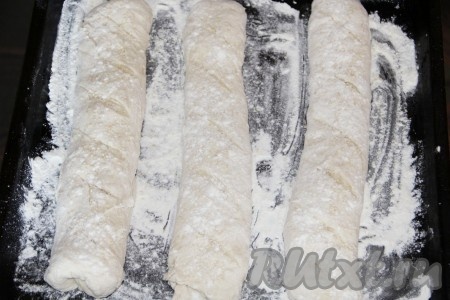 Посыпаем противень мукой и выкладываем наши домашние багеты швом вниз. Сверху делаем надрезы, присыпаем кунжутом и мукой. Багеты из теста, замешанного на живых дрожжах, выпекаем в разогретой до 250 градусов духовке 10 минут. Затем уменьшаем температуру 200 градусов и печём ещё 10-15 минут (до красивого золотистого цвета).