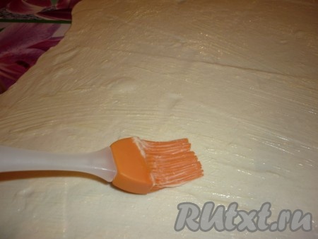 Тесто разделить на две части. И каждую очень тонко раскатать. Смазать с помощью кисточки растопленным сливочным маслом.
