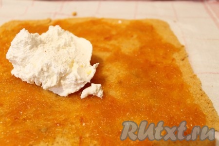 Остывший бисквит развернула, смазала слоем джема, затем сверху распределила сливки.
