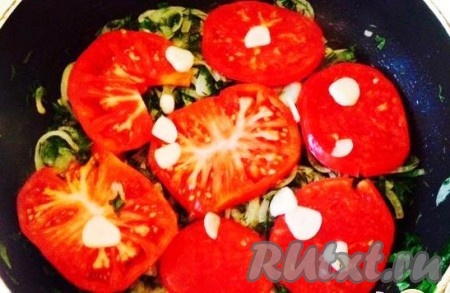 Поверх лука и зелени выкладываем слой помидоров и нарезанный пластинками 1 зубчик чеснока.
