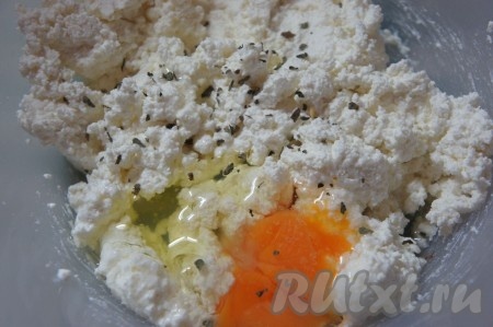 К творогу добавить яйцо, соль, растительное масло, сушёный базилик (можно добавить и мелко нарезанный свежий базилик, тогда творожно-кабачковая запеканка получится более ароматной), перемешать.