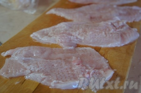 Куриную грудку вымыть, обсушить, разделать на два филе. Каждое филе разрезать вдоль, чтобы получилось 2 куска. Отбить каждый кусочек мяса с двух сторон. В итоге из 1 куриной грудки получатся 4 отбивные.