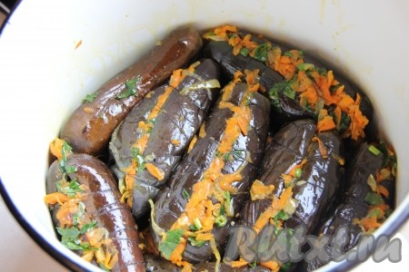 Каждый баклажан фаршируем полученной овощной массой и обматываем ниткой. Плотненько выкладываем баклажаны в миску (или кастрюльку), сверху ставим пресс. Через 2-3 часа масло должно покрыть наши баклажаны полностью. Если этого не произошло, добавьте сверху ещё масла.