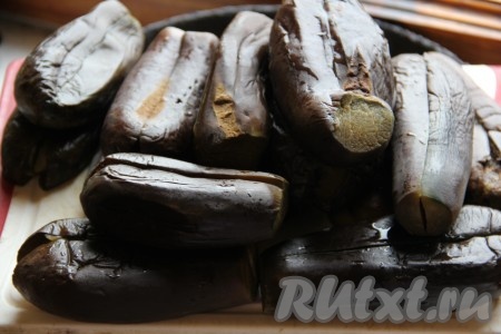 Баклажаны очищаем от хвостиков, разрезаем вдоль по серединке, не дорезая до самого конца. Баклажаны заливаем кипящей водой. Воды наливайте столько, чтобы хватило покрыть баклажаны. Соли добавляйте в воду из расчёта 1 столовая ложка на 1 литр используемой воды. Баклажаны отвариваем, примерно, 10 минут (в зависимости от размеров). Проверяем готовность баклажана спичкой. Если спичка входит с лёгкостью, баклажаны готовы. Ставим баклажаны под пресс, разрезом к верху. Под прессом держим 1-2 часа.
