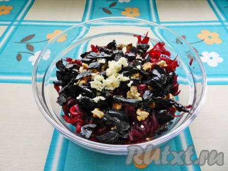 Чернослив нарезать, чеснок пропустить через пресс и добавить в салат к свекле и орехам.
