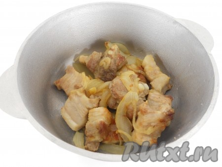 Луковицу очистить, нарезать полукольцами, выложить к зарумянившейся свинине и обжаривать на среднем огне в течение 5 минут, периодически перемешивая.