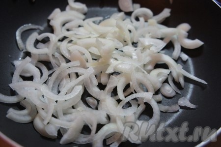 Лук очистить, нарезать полукольцами. На сковороде хорошо прогреть растительное масло, выложить полукольца лука, обжарить на среднем огне, иногда помешивая, до золотистости лука (ориентировочно в течение 5-6 минут), затем убрать с огня, дать немного остыть.