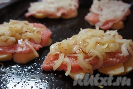 На картофель выложить отбитое мясо свинины, сверху разместить обжаренный лук.