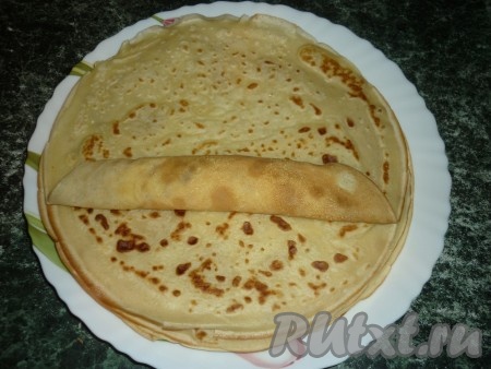 На край блина кладём начинку из творога и изюма и заворачиваем конвертиком.