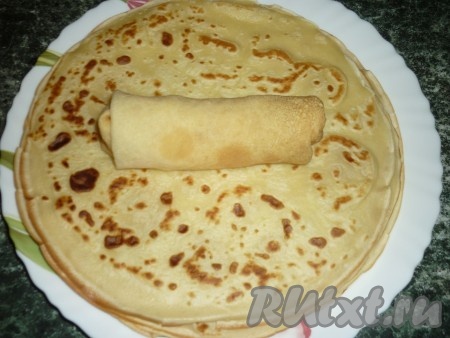 На край блина кладём начинку из творога и изюма и заворачиваем конвертиком.