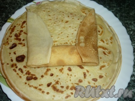 На край блина кладём начинку из творога и изюма и заворачиваем конвертиком.